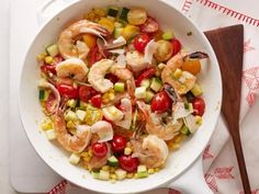 a white bowl filled with shrimp, corn and tomatoes