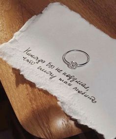 a piece of paper with a ring on it sitting on top of a wooden table