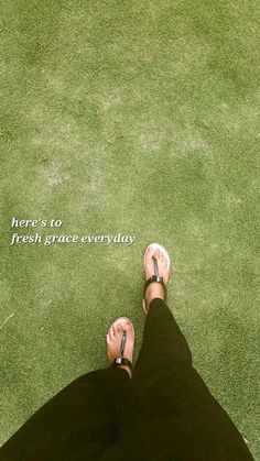 a person standing in the grass with their feet up and there's to fresh grace everyday