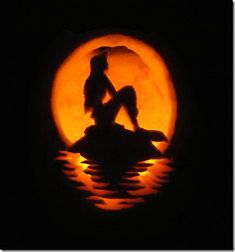 the silhouette of a woman sitting on top of a rock in front of a full moon