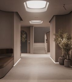 an empty hallway with stairs and potted plants