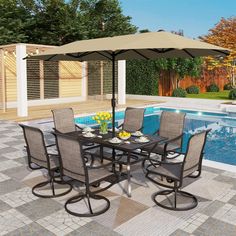 an outdoor dining table with umbrella over it next to a swimming pool in the backyard