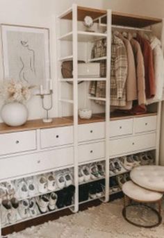 an organized closet with white drawers and shelves filled with shoes, sweaters and other items