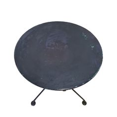 a round metal table with two legs and a black surface on top, against a white background