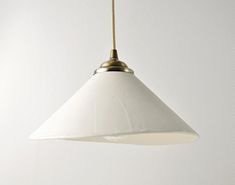 a white light hanging from a gold colored ceiling fixture in a living room or kitchen