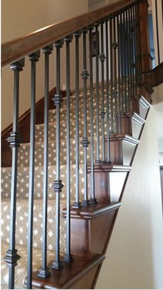 a staircase with metal handrails and wood treading in a residential home's entryway