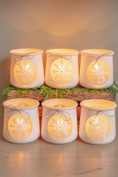 six snowflake candles are sitting next to each other on a wooden box with string