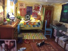 a room filled with lots of clutter and furniture next to a wall covered in posters