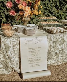 a table topped with plates and bowls filled with food next to a sign that says grand billi