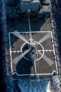 an aerial view of a helicopter on the deck of a ship