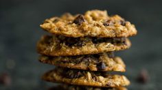 chocolate chip cookies stacked on top of each other in front of a black background,