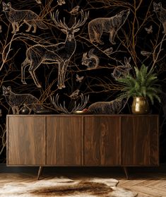 an animal themed wallpaper with deers and other animals on the sideboard in front of it