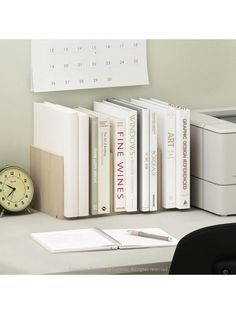 an office desk with books, printer and calendar