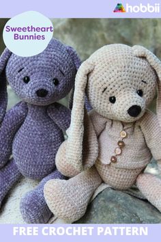 two crocheted stuffed animals sitting next to each other on top of a rock