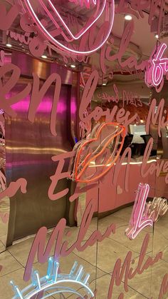 pink neon signs are hanging from the ceiling