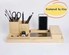 a cell phone, pen and pencil holder on a white surface with various office supplies