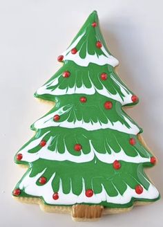 a decorated christmas tree cookie sitting on top of a table