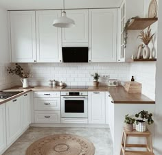 the kitchen is clean and ready for us to use it's white cabinets, wood countertops, and rugs