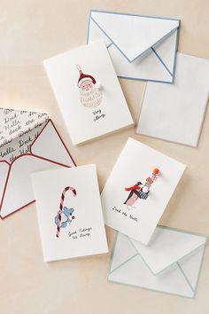 four christmas cards and envelopes on a table