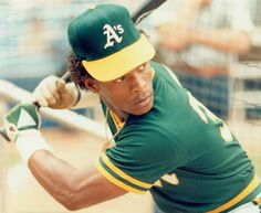 a baseball player holding a bat in his hand and wearing a green and yellow uniform