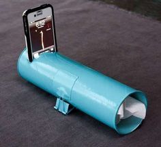 a cell phone is sitting in a blue tube on the ground next to an iphone