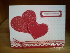 a card with two hearts on it and the words happy anniversary written in red ink