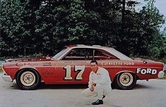 a man standing in front of a red car with the number 17 painted on it