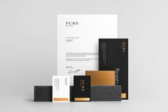 an assortment of business cards and envelopes in black, white, gold and grey