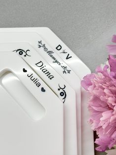 three personalized cutting boards with hearts on them next to a pink carnation flower