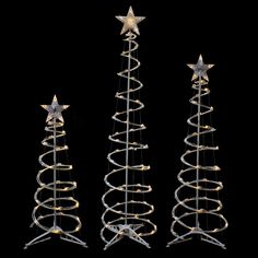 three metal christmas trees with stars on them