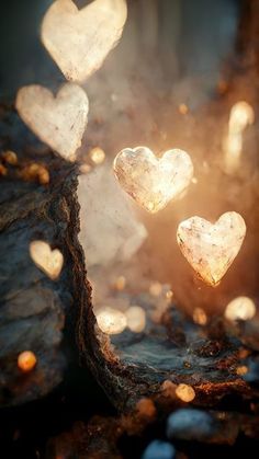 some heart shaped rocks sitting on top of a rock with light coming from them in the background