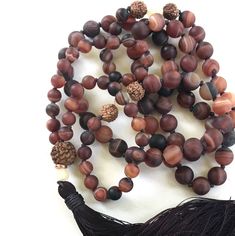 "Mala For Acceptance -Matte Dream Agate Beads Accented With Yellow Jade & Rudraksha - 108 Mala Bead Necklace - Hand Knotted - 8mm & 6mm Beads Length 36.5\" Gently release the body and the mind with this earthy Dream Agate Mala necklace from True Nature Jewelry. It features Dream Agate for grounding and centering along with Rudraksha and Jade in a free-spirited display of design. Each bead is expertly hand knotted for durability. The addition of Rudraksha brings clarity and peace of mind Brown Beaded Holistic Mala, Holistic Brown Beaded Mala, Adjustable Agate Hand-strung Mala, Bohemian Brown Mala With Natural Stones, Adjustable Hand-strung Agate Mala, Spiritual Brown Agate Beads, Brown Hand Knotted Mala For Healing, Brown Hand Knotted Mala With Round Beads, Hand Knotted Brown Mala For Healing