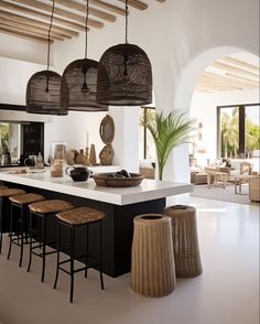 a large kitchen with lots of counter space and hanging lights above the island in front of it