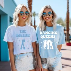 two women wearing matching t - shirts with the words dancing queens printed on them, standing next to each other