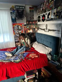 a person laying on top of a bed in a room filled with posters and books