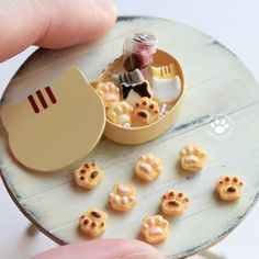 a person is holding a tiny toy animal in a box with other small animals inside