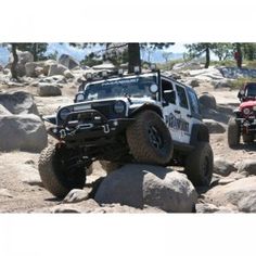 two jeeps driving on rocks in the desert