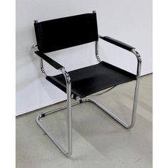 a black leather and chrome chair against a white wall