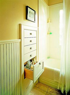 a white dresser sitting next to a bath tub