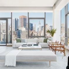 a living room filled with lots of furniture and tall buildings in the backround