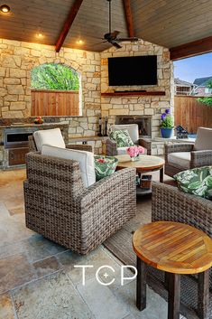 an outdoor living area with wicker furniture and a flat screen tv on the wall