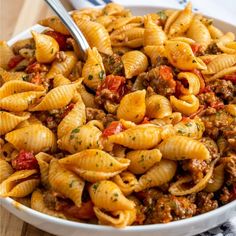 a white bowl filled with pasta and meat