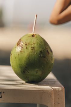 a green coconut sitting on top of a wooden table