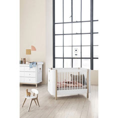 a baby's room with white furniture and large windows