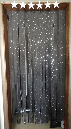 an open door with stars hanging from it's side and some curtains on the outside