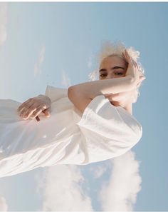 a woman with white hair standing in the sky