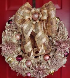 a christmas wreath hanging on a red door with ornaments around it and an ornament in the center