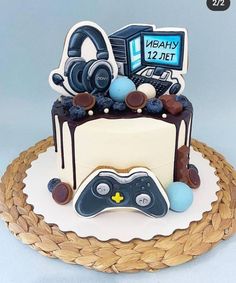 a birthday cake with a video game controller and headphones on top, sitting on a wicker platter