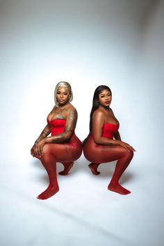 two women in red bodysuits sitting next to each other