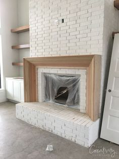 a white brick fireplace with a wooden mantle